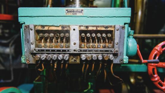 Teal and brown electric connector box with wires converging using screws, so quite aged