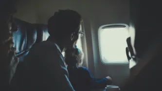 Man and girl looking out airplane window