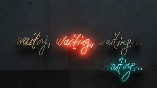 Four neon light signs saying repeatedly the word 'waiting'