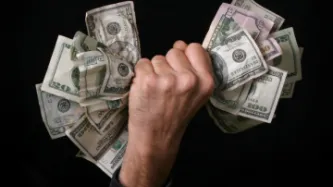 A wad of money being grabbed in a hand